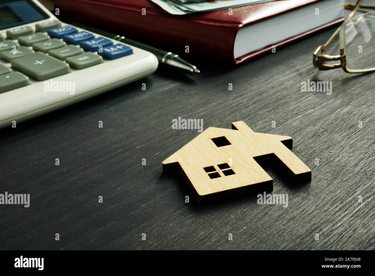 Model of home on the desk. Property worth and mortgage concept. Stock Photo