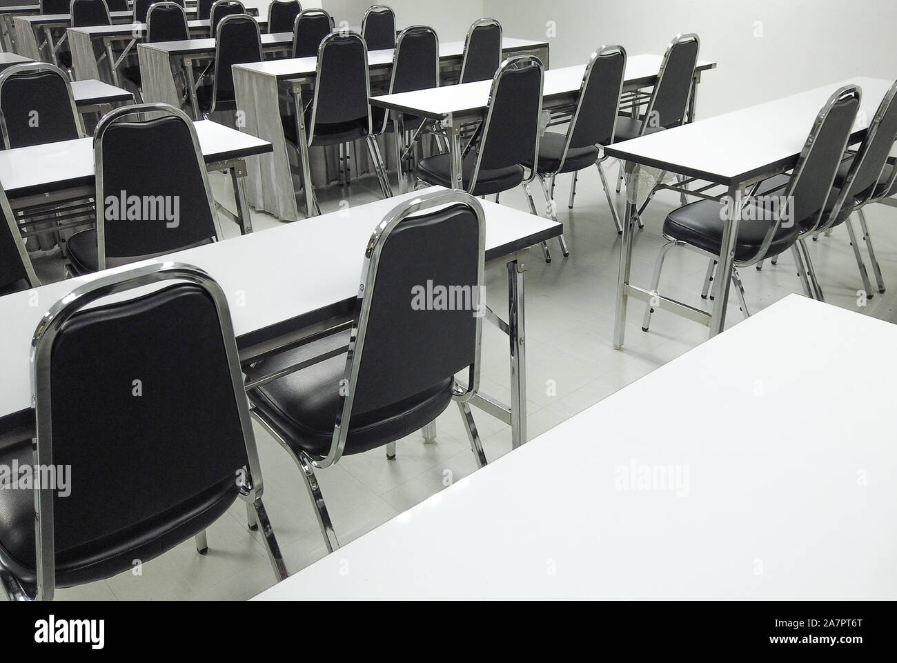 Empty nobody chairs and desks in classroom background. Stock Photo