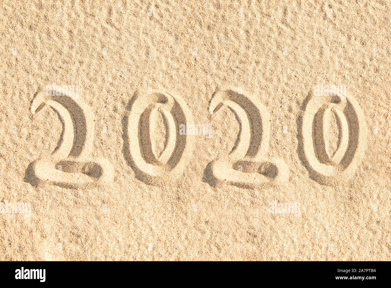 Year 2020 written in the sand of a beach, new year card Stock Photo