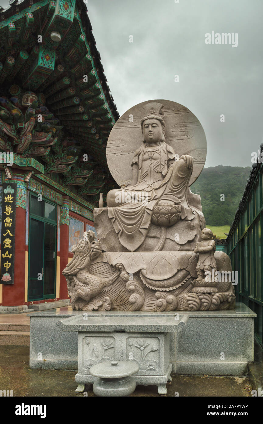 Jeju Island, South Korea, september 08, 2019: beautiful buddha statue  and part of the temple at the base of Seongsan Ilchulbong Peak Stock Photo