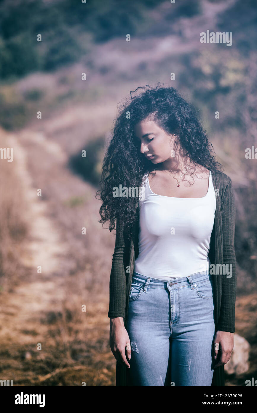 Sad young woman standing in the countryside Stock Photo