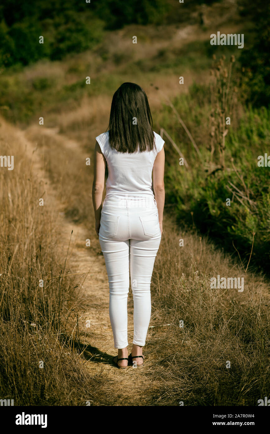 Rear view of young woman standing outdoors Stock Photo