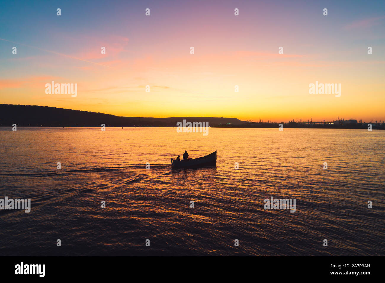 Sunset over fishing boat and shining golden sea water Stock Photo - Alamy