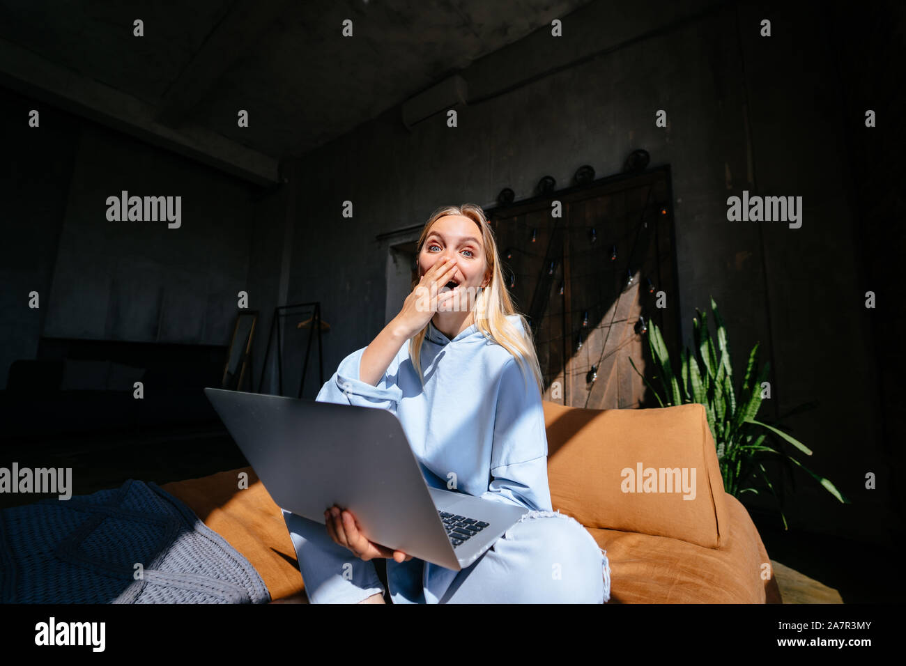 Smiling attractive woman lying on bed using laptop Stock Photo - Alamy