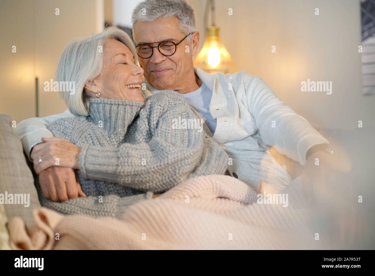 Lovely looking senior couple relaxing together on couch at home Stock ...