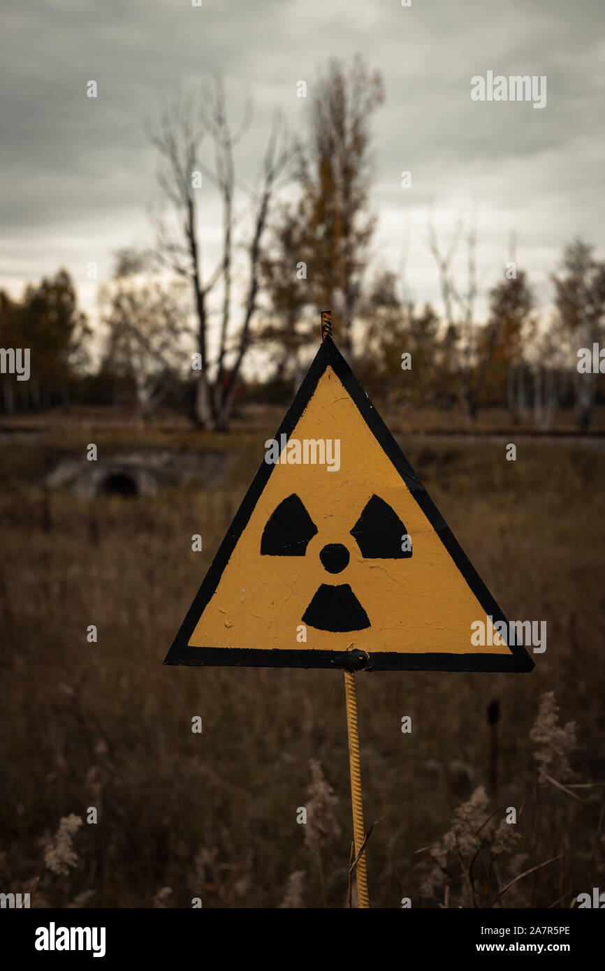 Yellow radioactive sign in the Chernobyl exclusion zone near the ghost town of Pripyat and the Chernobyl nuclear reactor (Kiew, Ukraine, Europe) Stock Photo