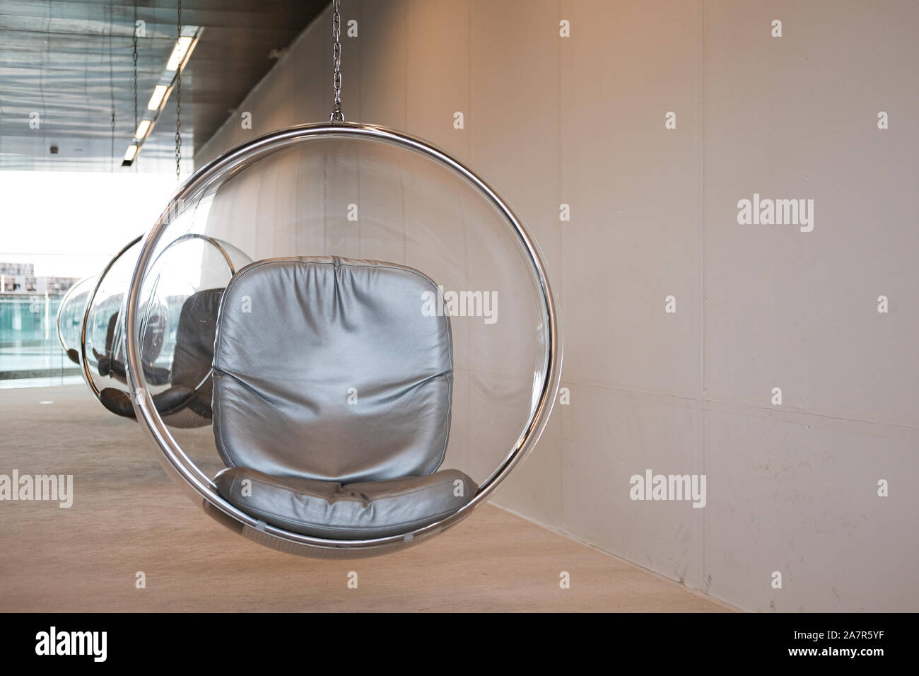 The suspended Eero Aarnio bubble chairs at the National Library in Education in Qatar provide a quiet reading space. Stock Photo
