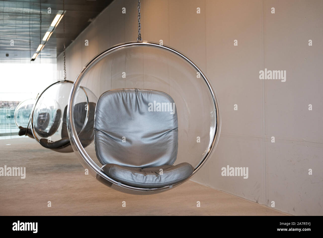 The suspended Eero Aarnio bubble chairs at the National Library in Education in Qatar provide a quiet reading space. Stock Photo