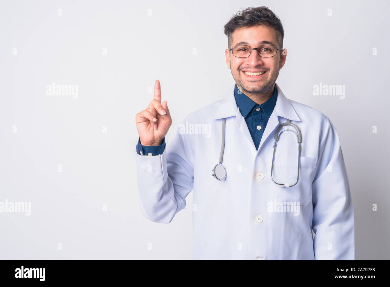 Portrait of happy Persian man doctor pointing up Stock Photo
