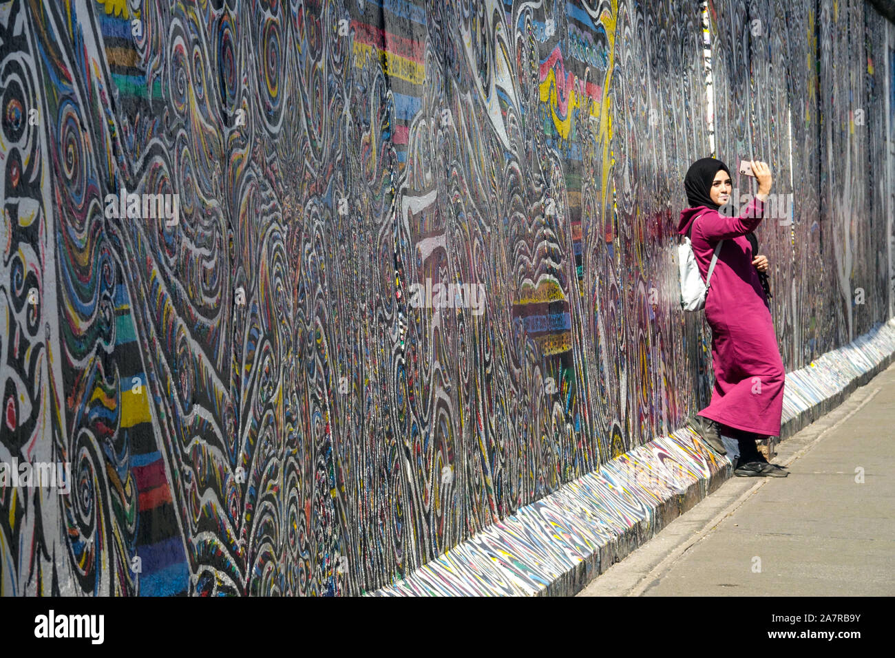 Berlin wall woman young Arab woman  take a selfie at East Side Gallery Germany Stock Photo