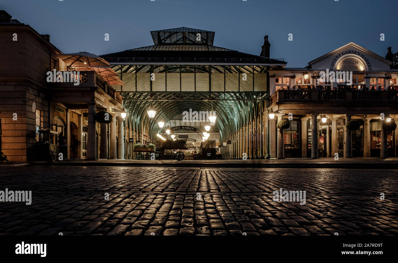 Covent Garden, London, at night.  The lights of the old flower marker are reflecting on the wet cobble stones Stock Photo