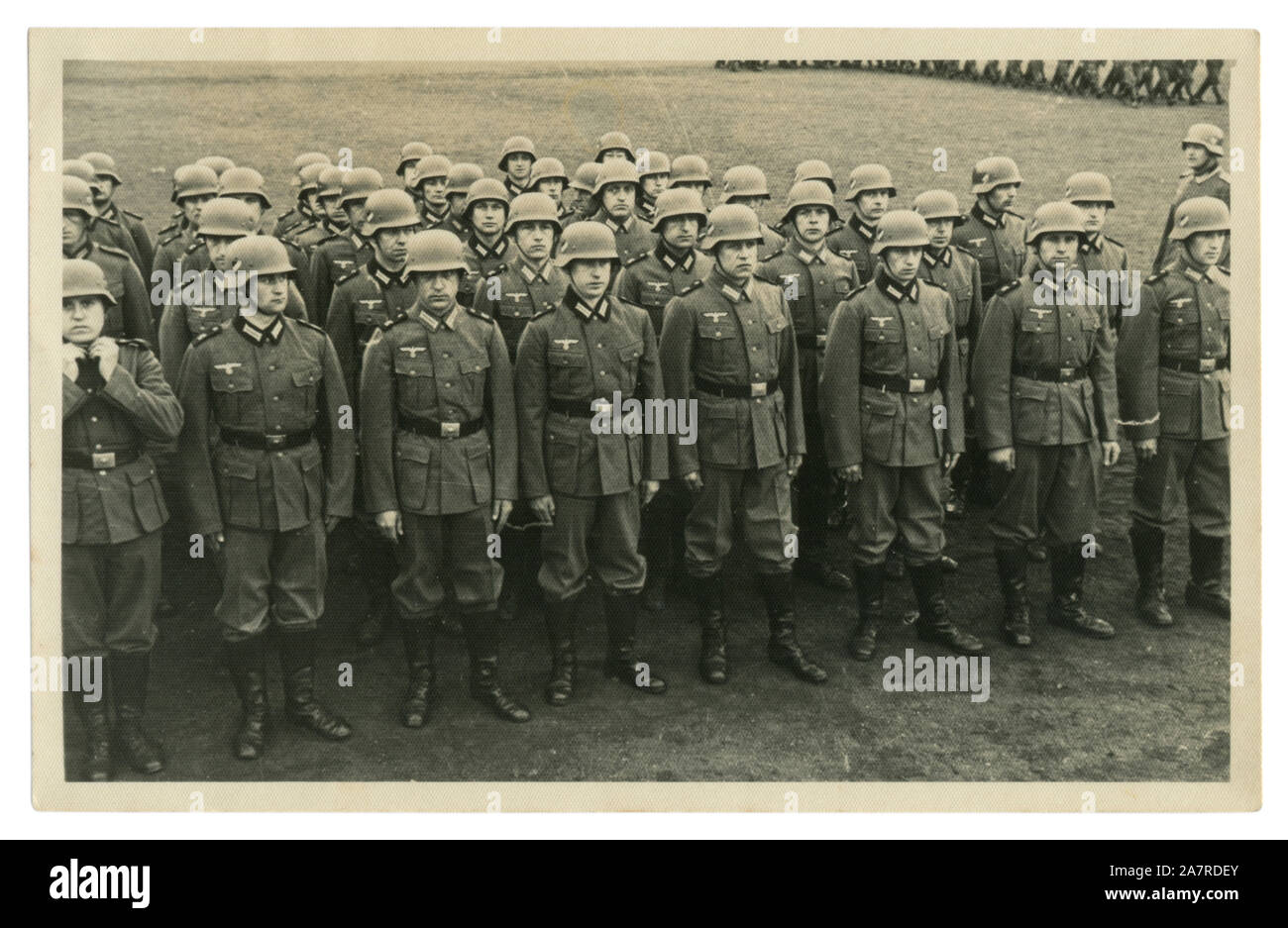 German historical photo: company of Wehrmacht soldiers on the parade ground in military uniform in steel helmets, leather boots, Germany, Third Reich Stock Photo