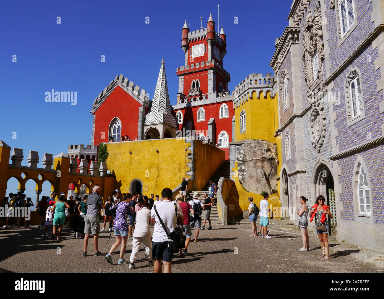 Portugal: Sintra, UNESCO World Heritage Site. Group of tourists visiting the Pena National Palace, an exuberant building in bright yellow and red colo Stock Photo