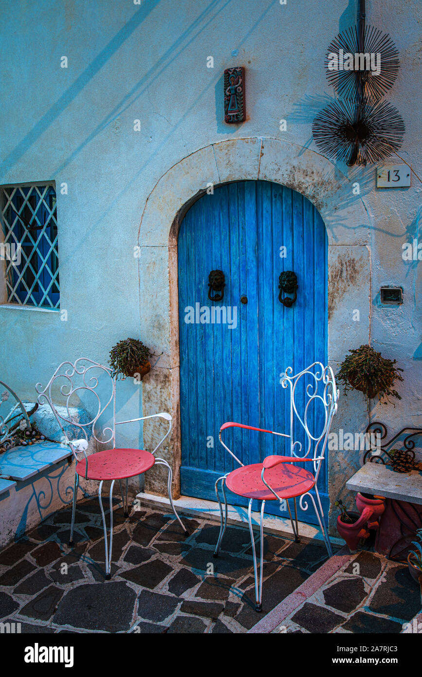 two pink chairs and one bleu door. Abruzzo Region, Italy, Europe Stock Photo
