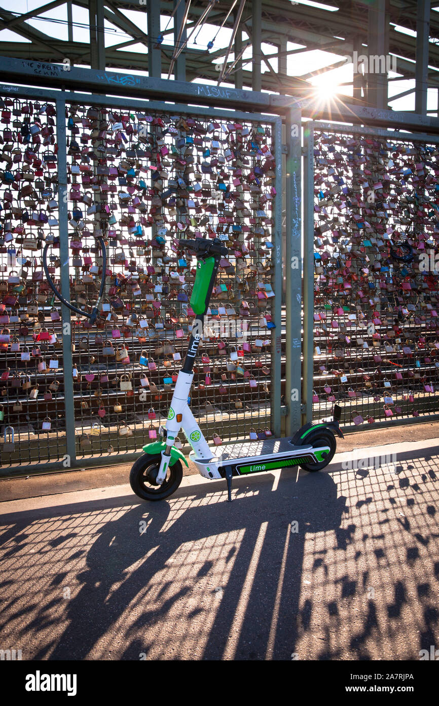 Lime electric scooter to rent on the Hohenzollern bridge, Cologne, Germany.  Lime Elektroscooter zum mieten auf der Hohenzollernbruecke, Koeln, Deutsc Stock Photo