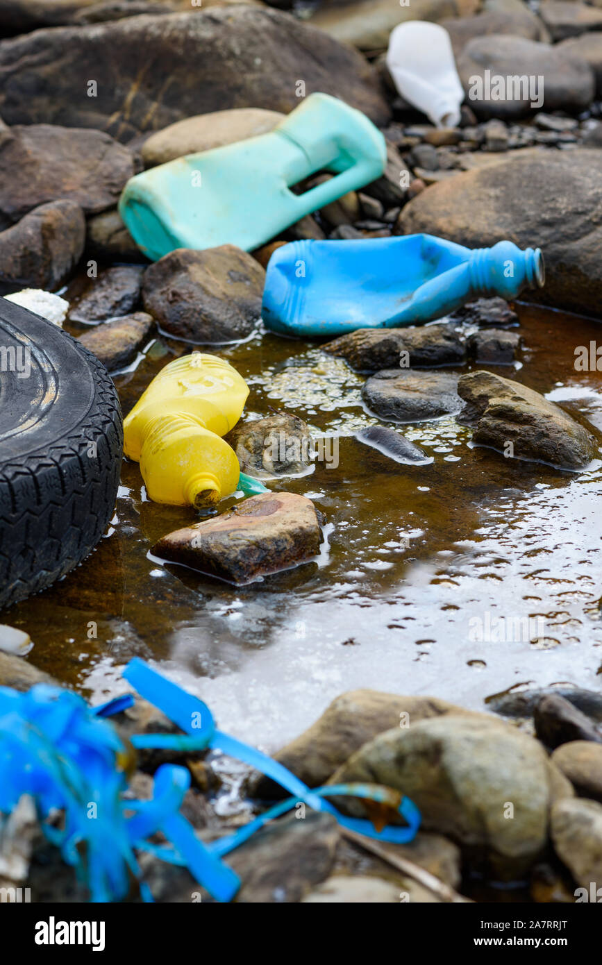 Plastic bottles old tire and styrofoam in dirty water. Global