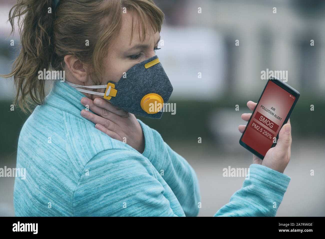 Woman wearing a real anti-pollution, anti-smog and viruses face mask and  checking current air pollution with smart phone app Stock Photo - Alamy