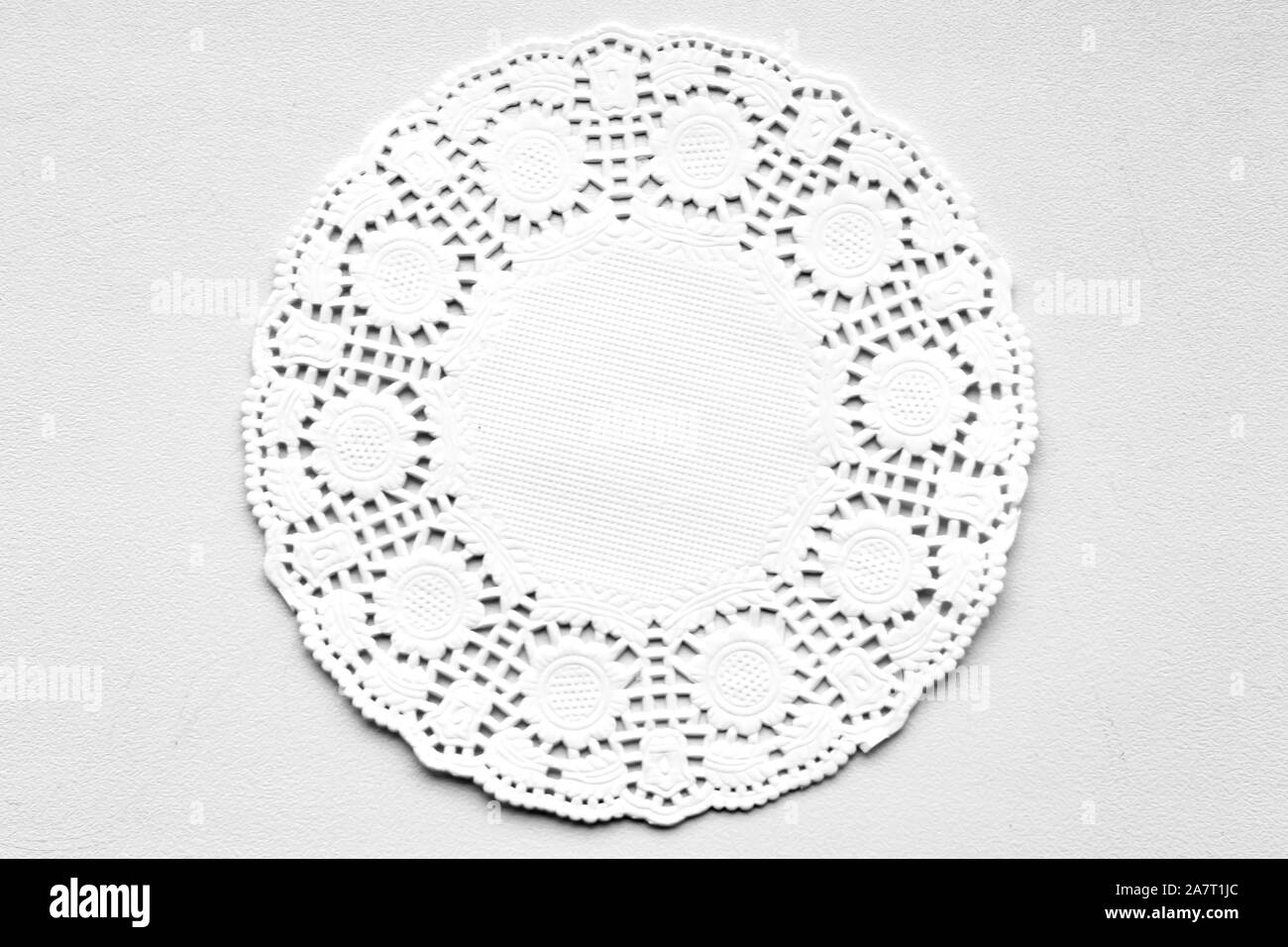 White decorative paper round napkin on a white-gray background. View from above. Stock Photo