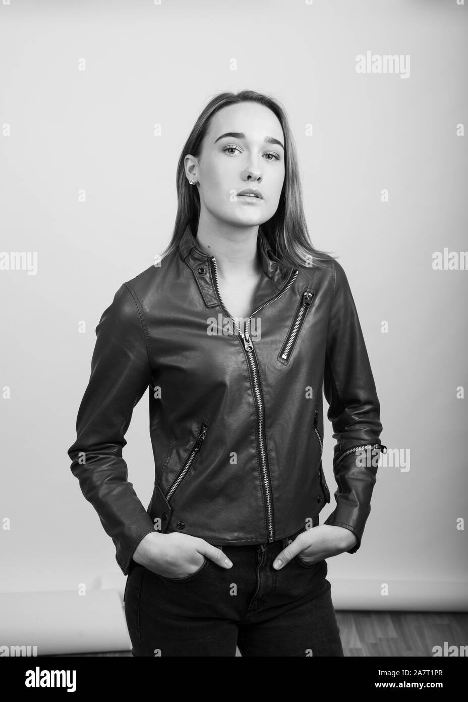 Grayscale portrait of a young woman wearing a leather jacket Stock Photo