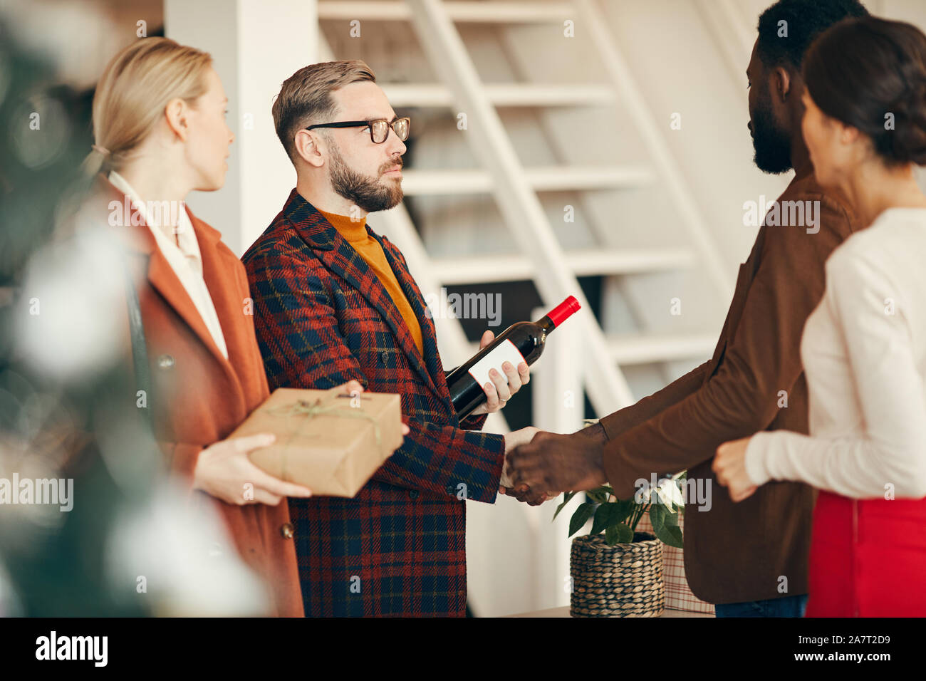 Side view portrait of modern couple welcoming guests to elegant dinner ...