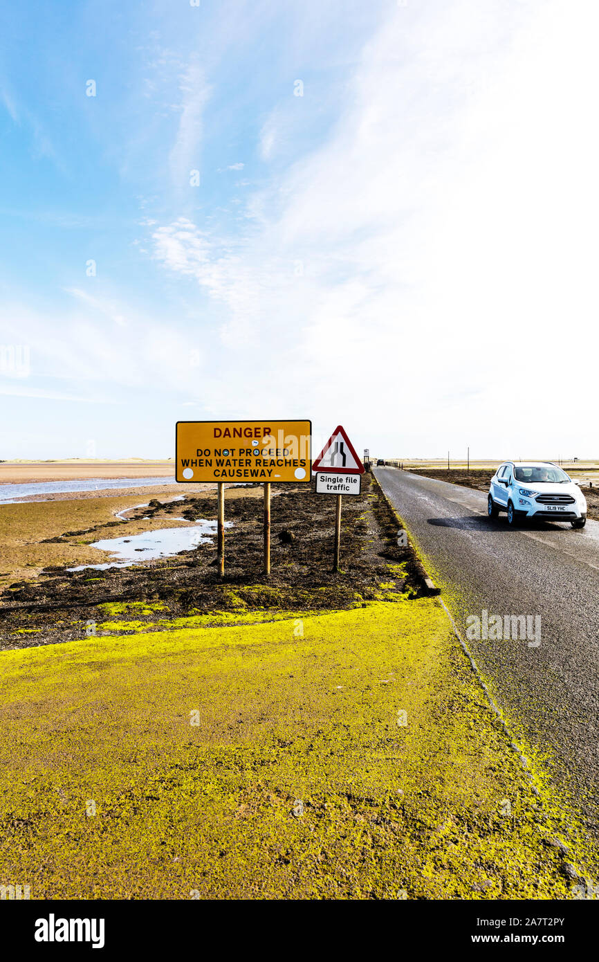 lindisfarne causeway sign, lindisfarne causeway signs,  lindisfarne, causeway,  holy island, northumberland UK, England, tide out, danger sign, danger Stock Photo