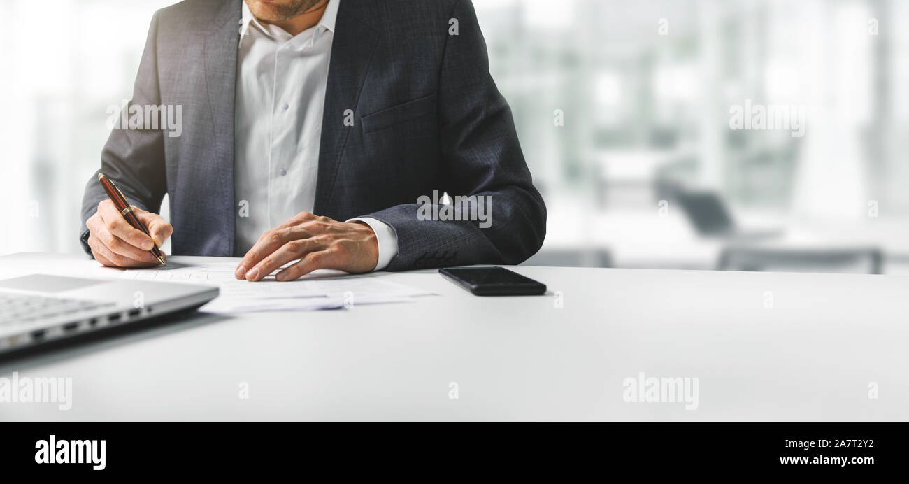 businessman signing business contract papers in bright modern coworking office. copy space Stock Photo