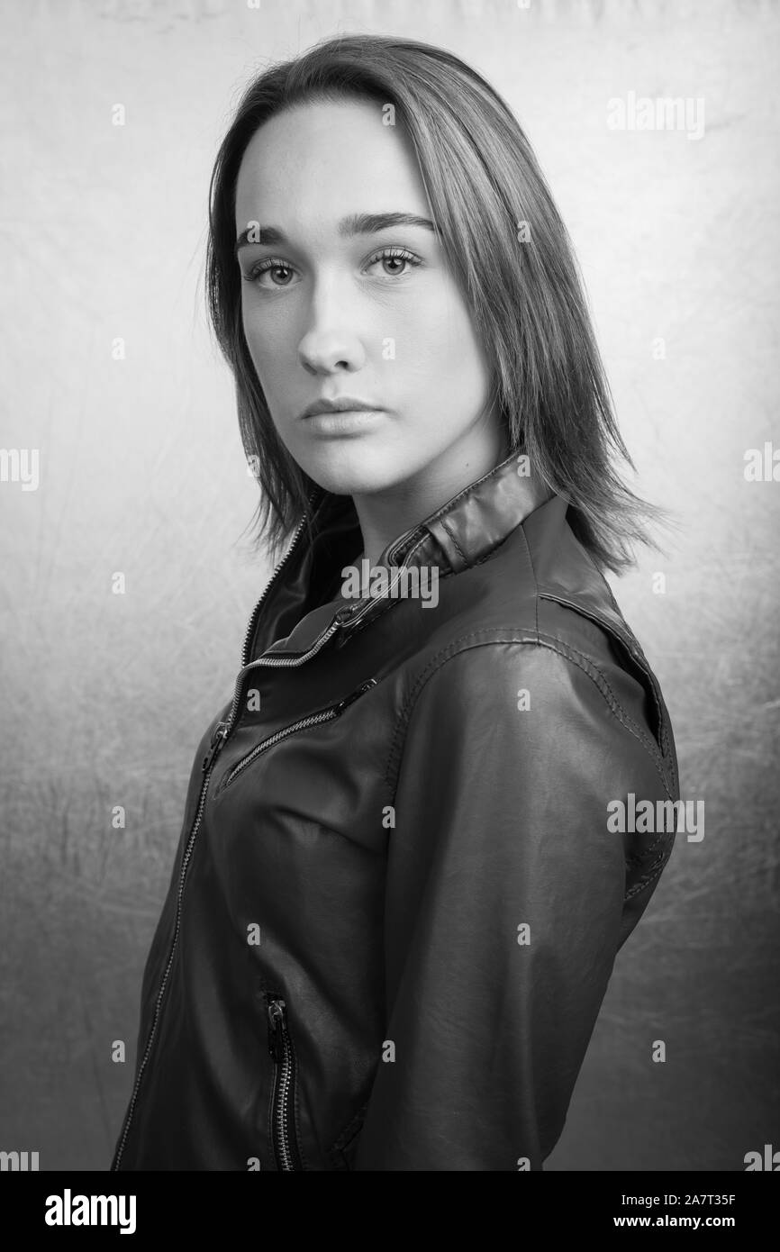 Grayscale portrait of a young woman wearing a leather jacket Stock Photo