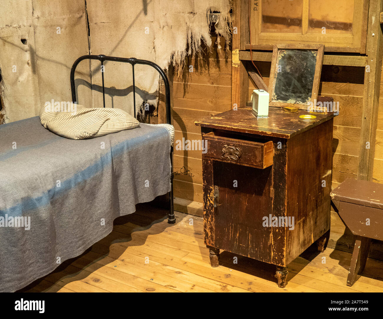 Display of a typical Australian farmhouse bedroom with single bed and bedside cabinet exhibit National Wool Museum Geelong Victoria Australia. Stock Photo