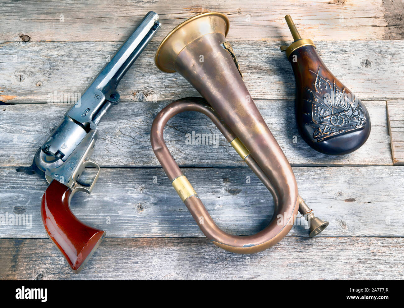 Antique cowboy pistol, brass buglel and  gunpowder flask. These would be items a civil war soldier would carry. Stock Photo