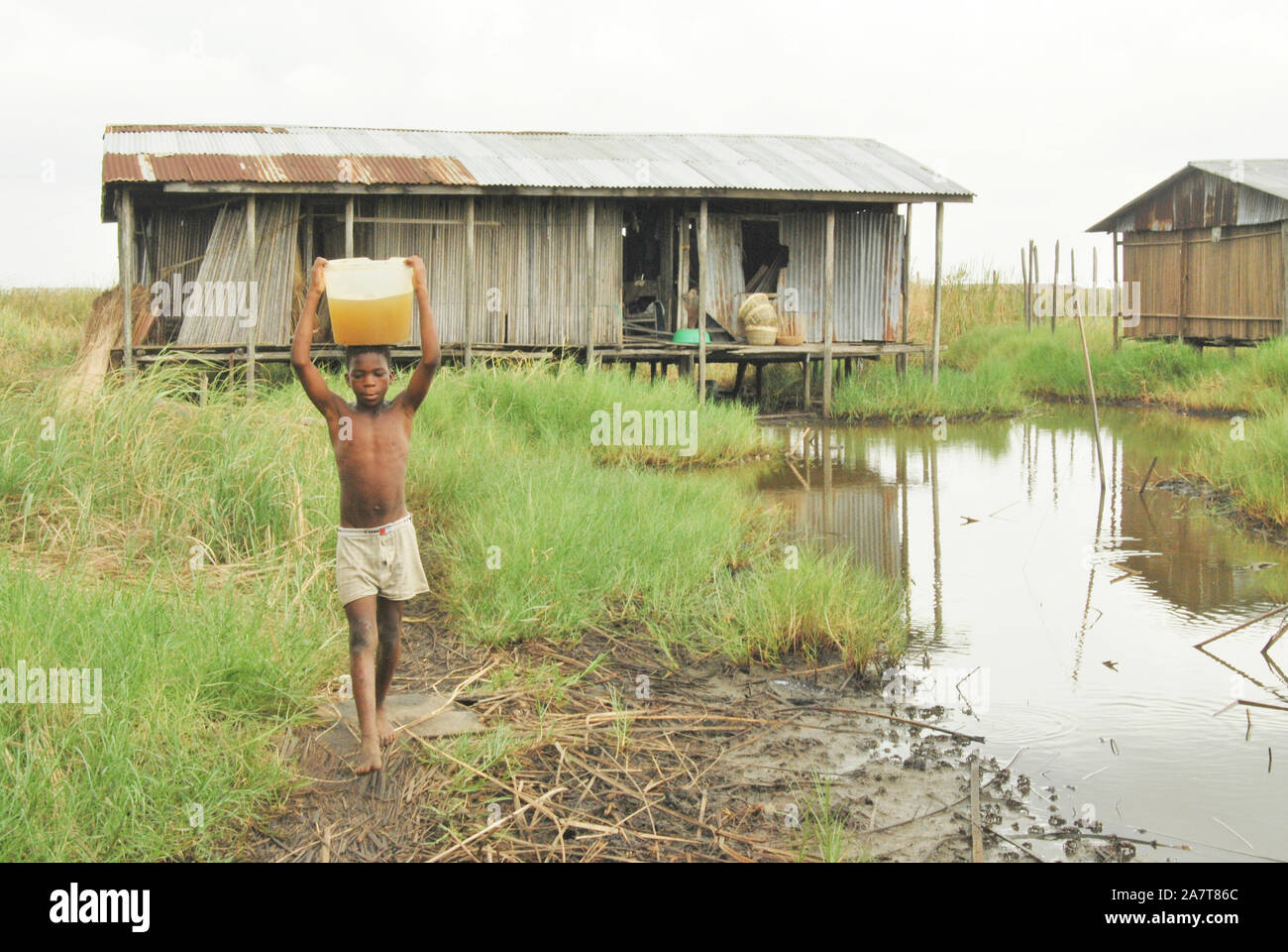 A boy fetching polluted water for drinking at Idi-Ogba, Ondo State, Nigeria. Stock Photo
