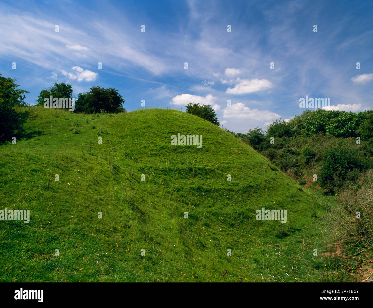 View W of Tomen y Rhodwydd motte and bailey castle, Denbighshire, Wales, UK, showing N bank & surrounding ditch of the bailey where it joins the motte Stock Photo