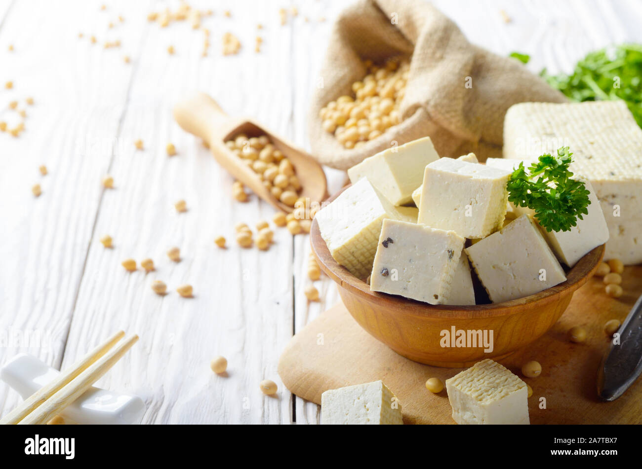Soy Bean curd tofu in wooden bowl and in hemp sack on white wooden
