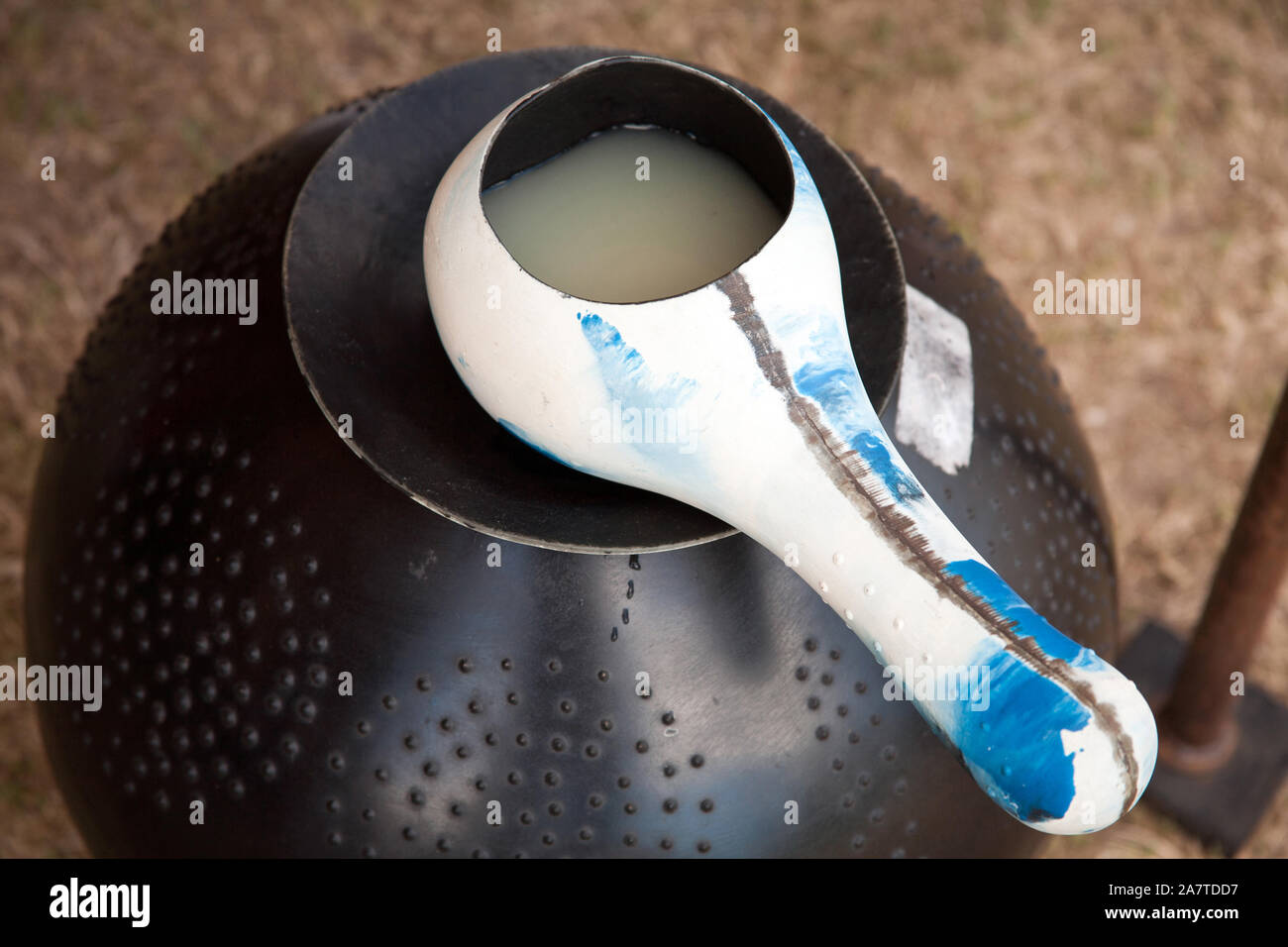 Marula beer in a traditional Zulu claypot with a scoop made from the