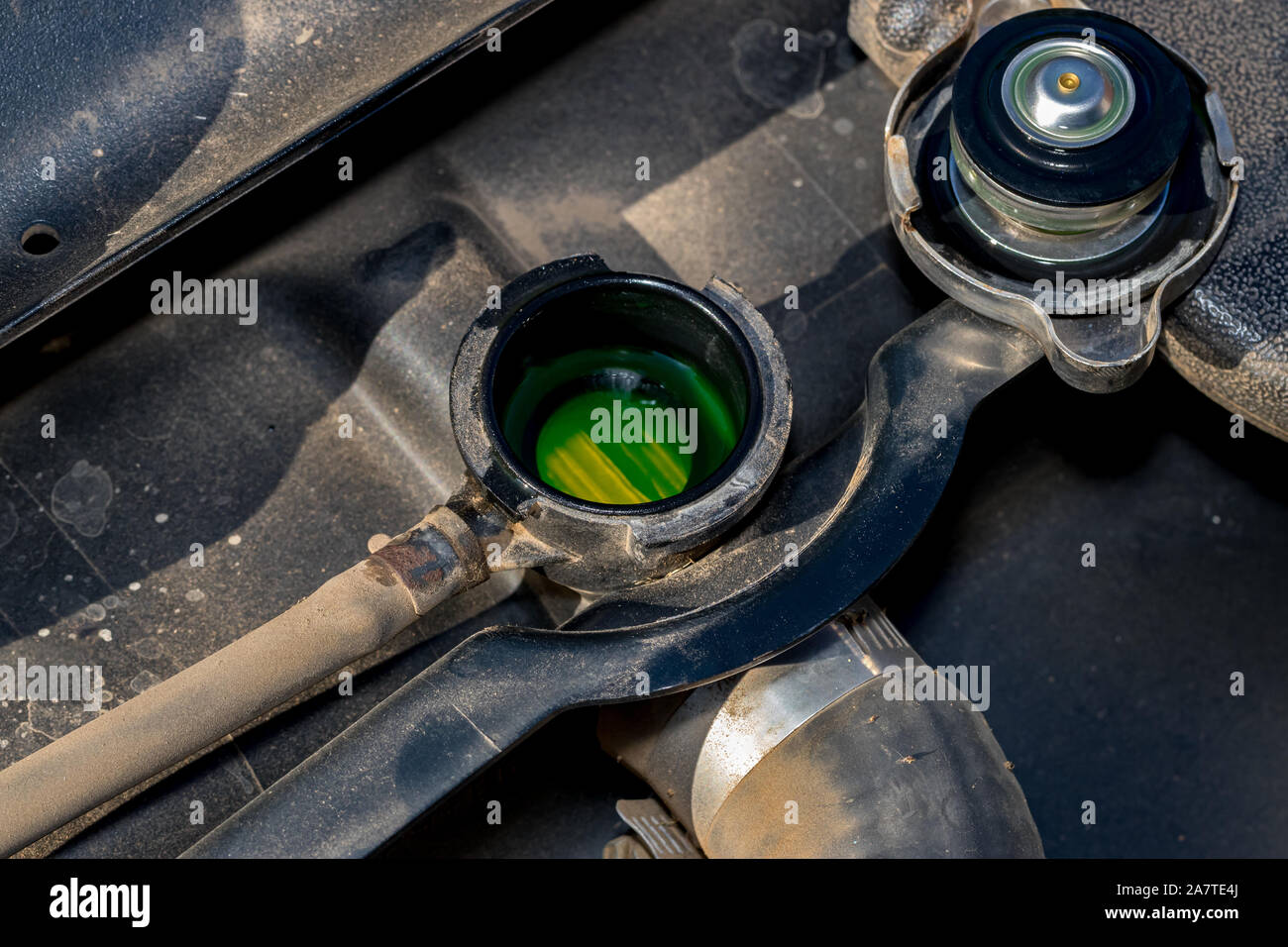 Cooling system radiator with cap removed showing green antifreeze coolant level. Concept of automotive and lawn equipment maintenance and repair Stock Photo