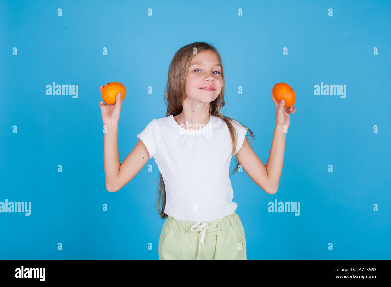 Beautiful little girl holding an orange fruits Stock Photo - Alamy