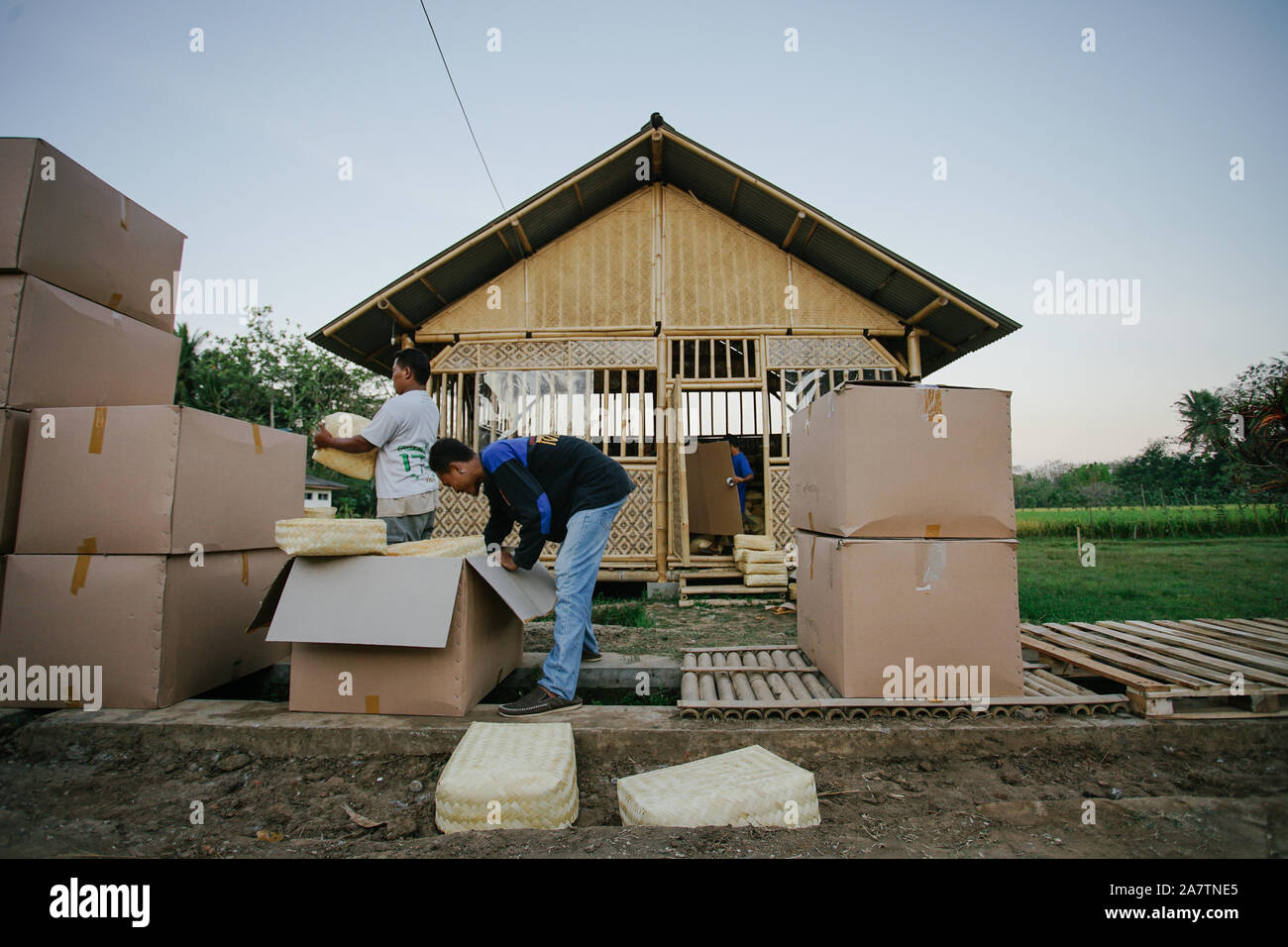 Workers packing traditional woven bamboo containers, "besek" into boxes