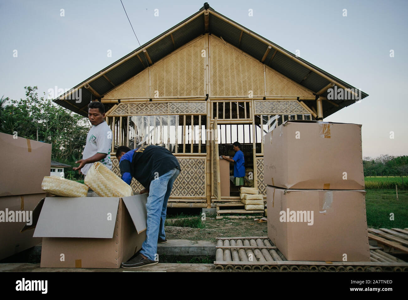 Workers packing traditional woven bamboo containers, "besek" into boxes