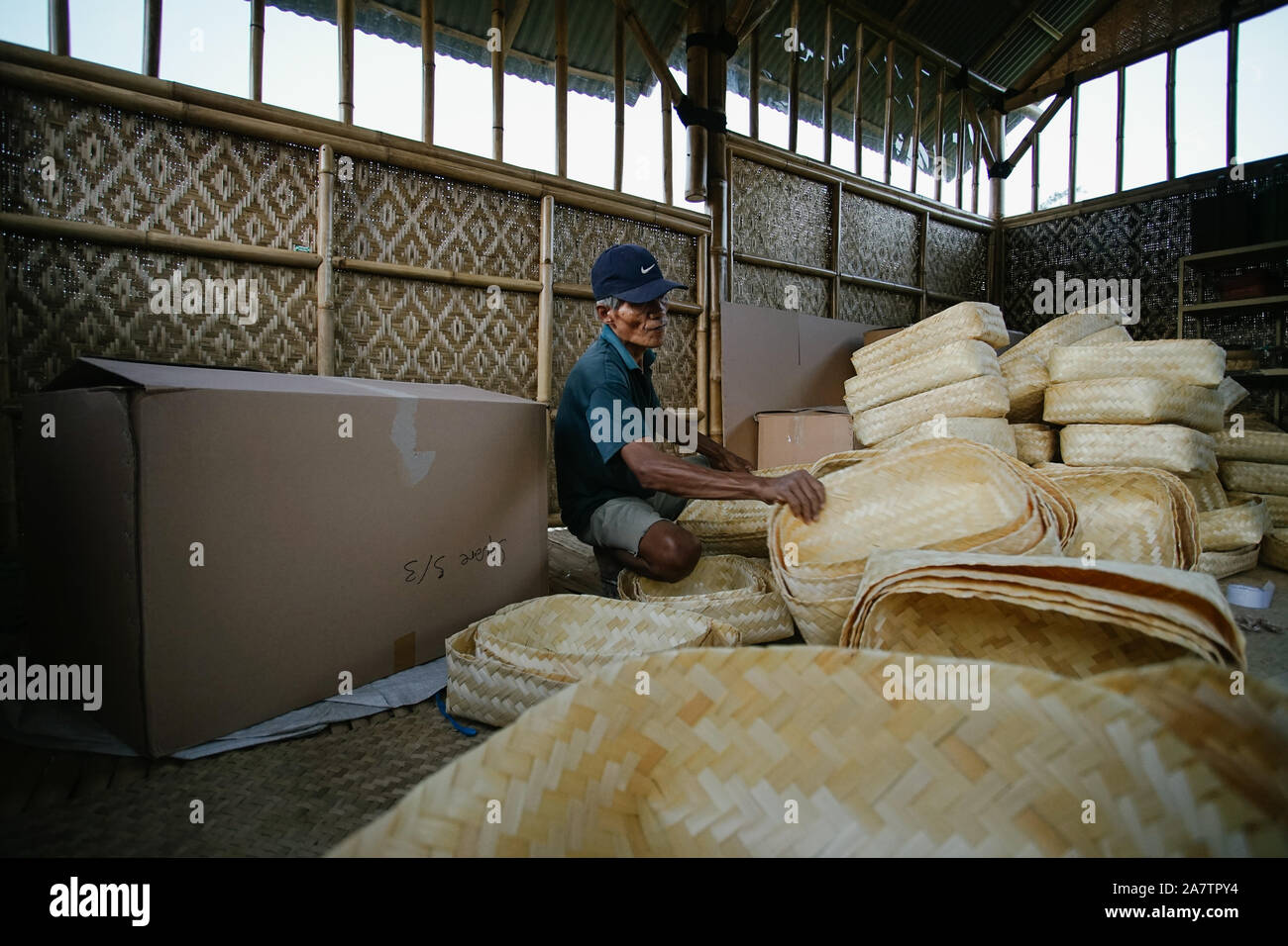 Workers packing traditional woven bamboo containers, "besek" into boxes