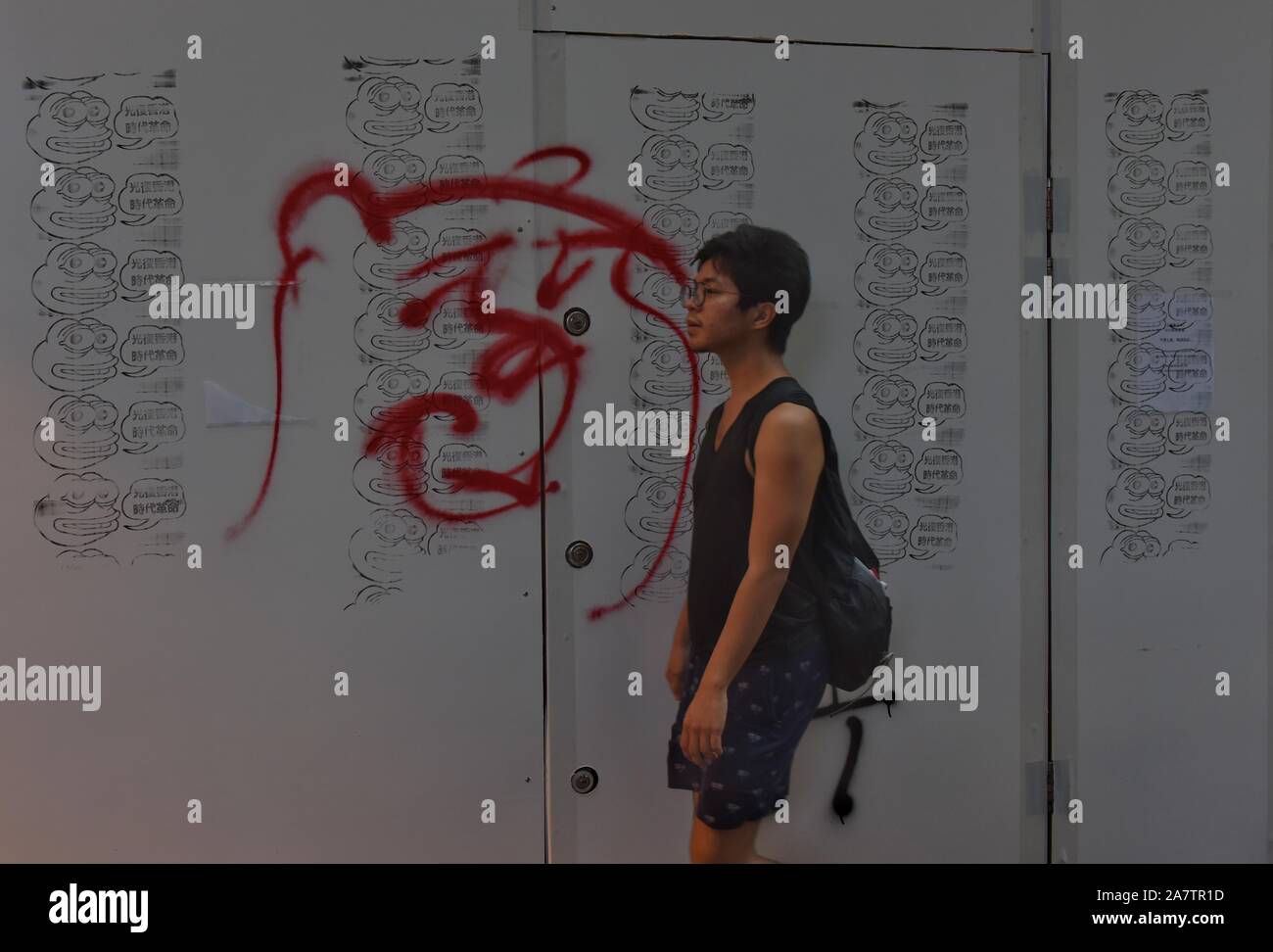 A man walks past a graffiti during the protest.The pro-democracy movement was originated with the outcry against the extradition bill. Hong Kong has entered 22nd week continued mass protests. Stock Photo