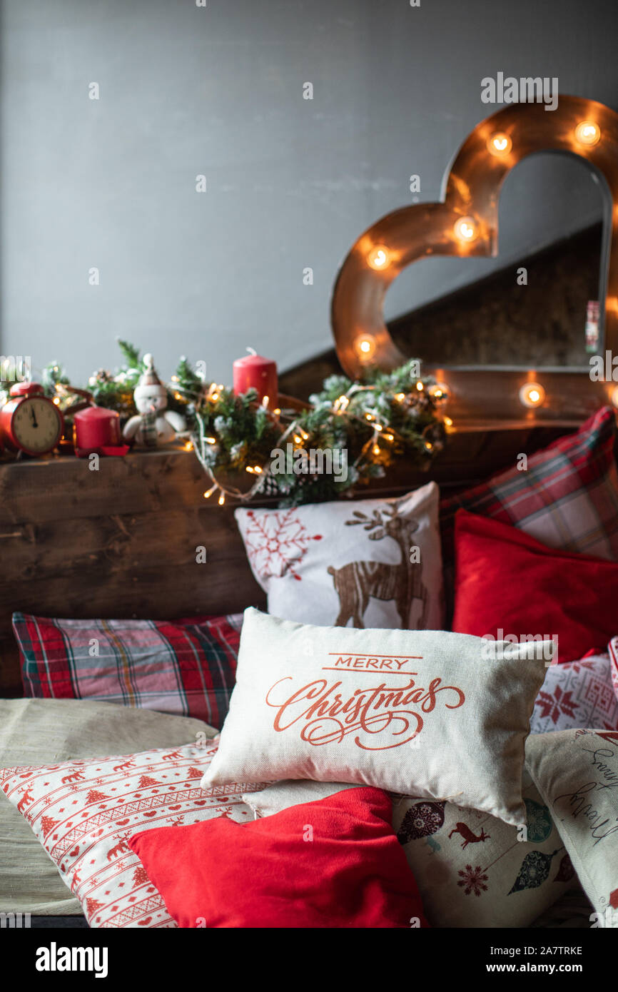 Cozy bed with Christmas pillows decorated with Christmas decor Stock Photo  - Alamy