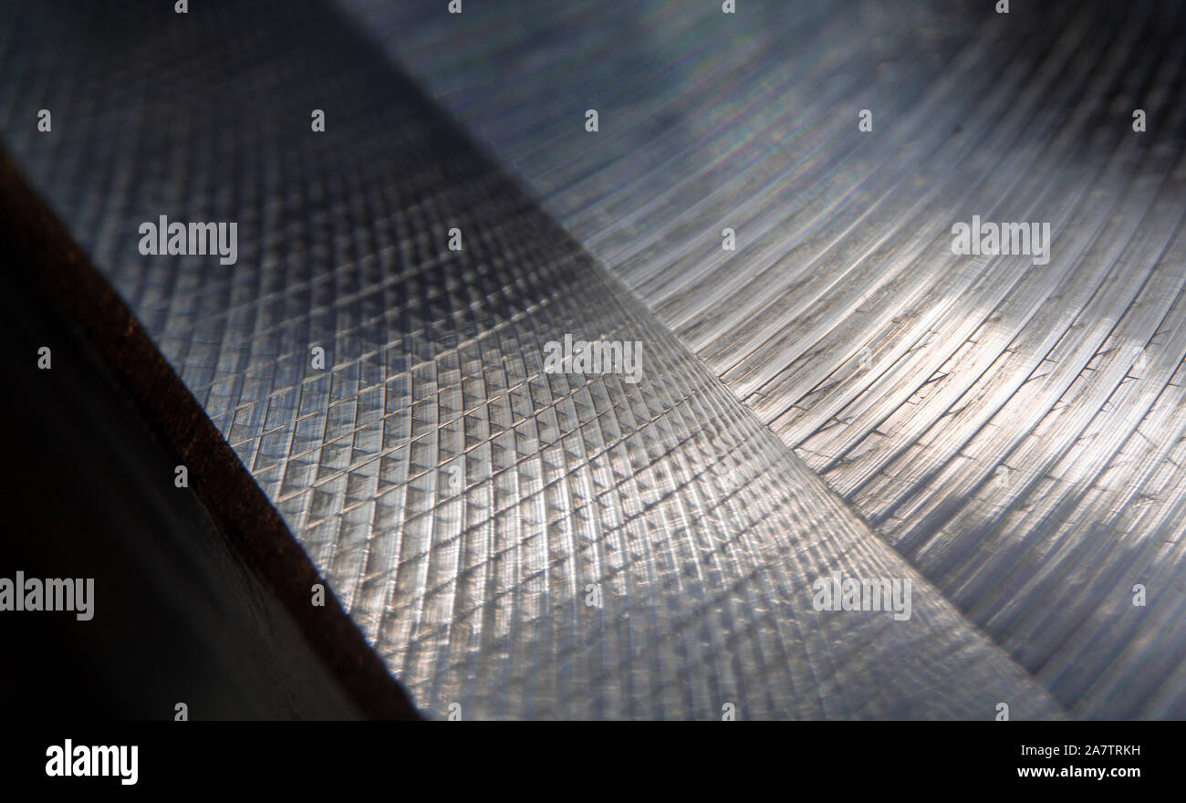 Close-up of industrial realistic gray color stainless steel flat part in partial focus after industrial CNC routing processing with high contrast abst Stock Photo