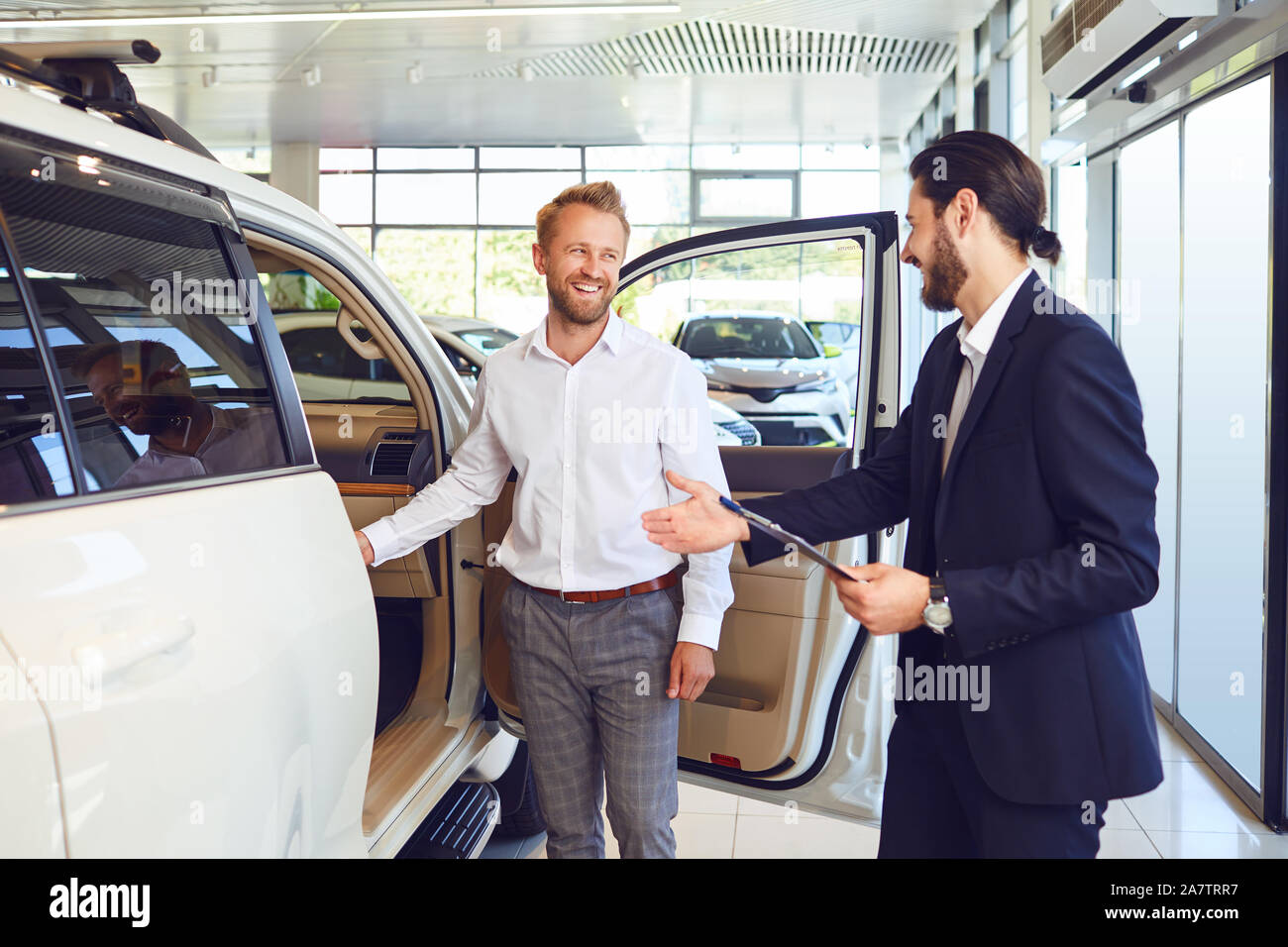 Professional salesmen selling cars at dealership to buyer Stock Photo Alamy