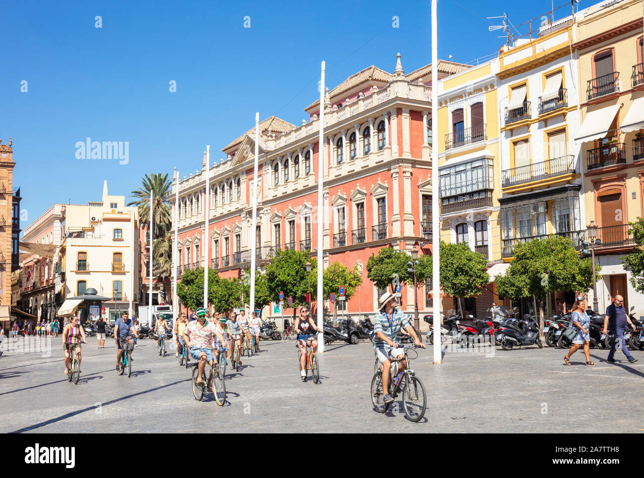 A cycle tour passing Typical spanish architecture of Buildings in the Plaza de San Francisco Seville Spain EU Europe Stock Photo