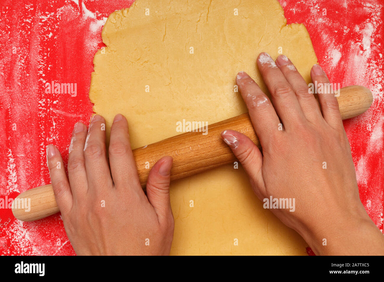 Female hands roll out the dough for Christmas cookies. Stock Photo