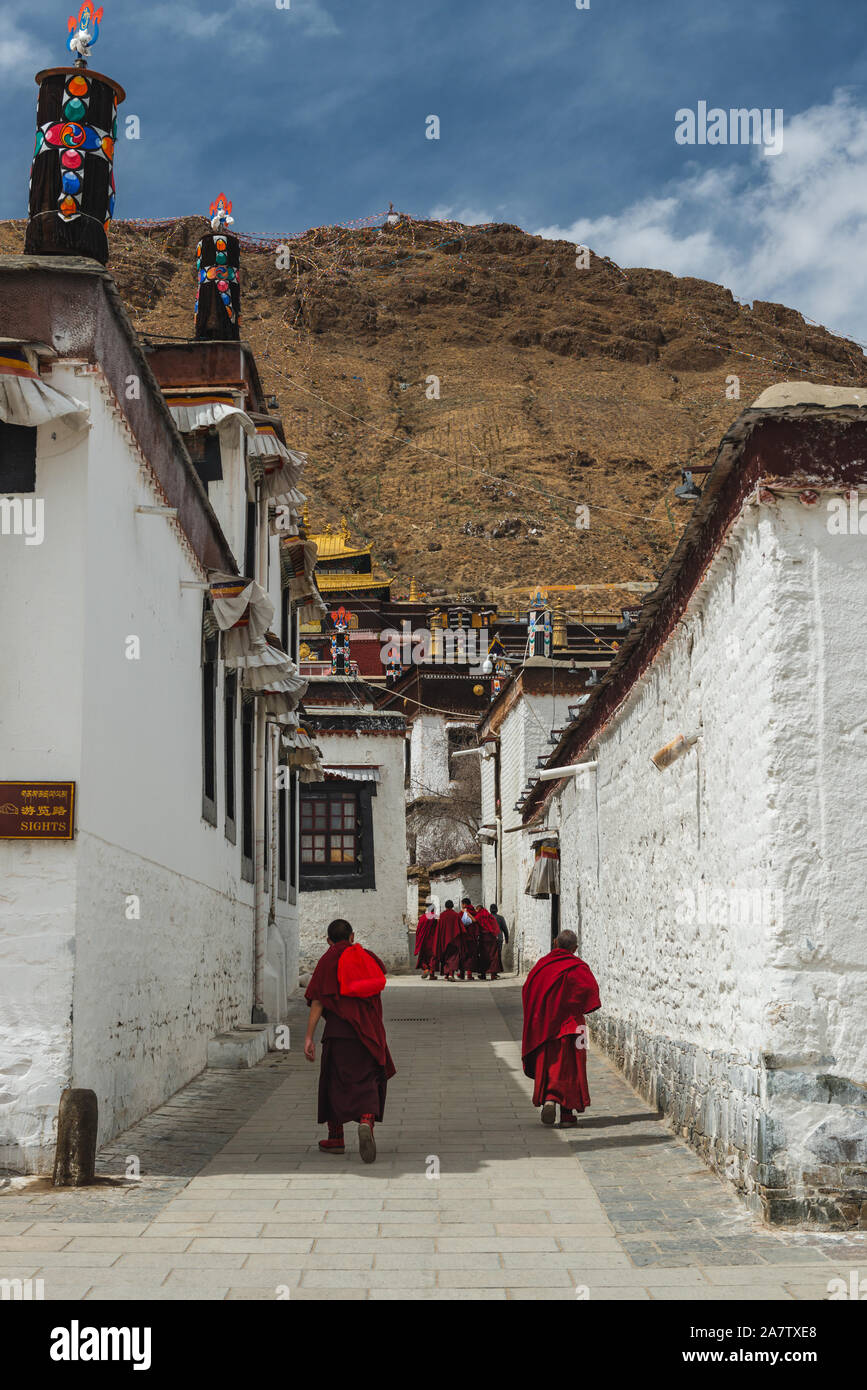 Shigatse, China - April 6, 2019: A Tibetan monks walk through the courtyard of a Buddhist temple in Shigatse, Tibet. Stock Photo