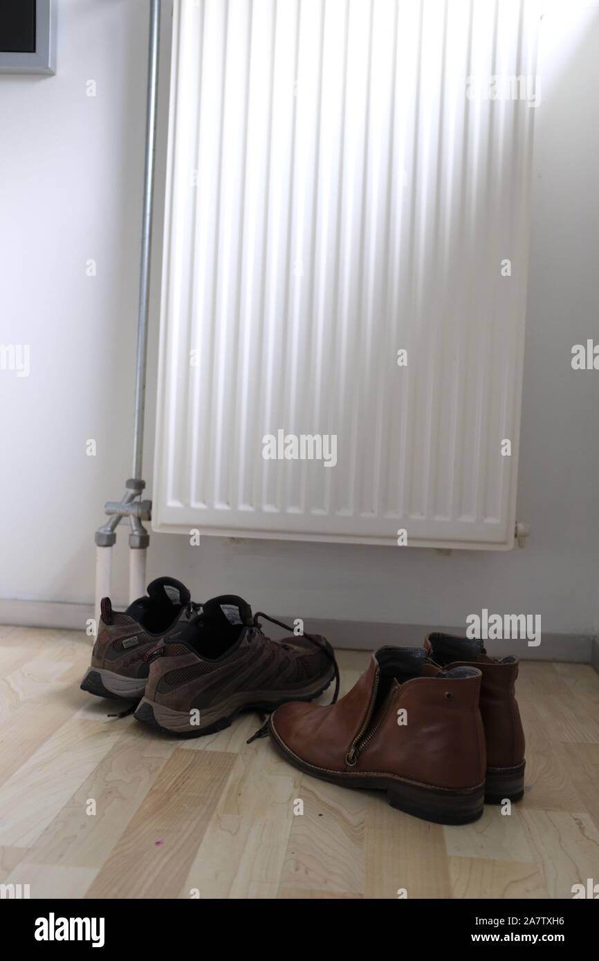 shoes close to the radiator drying up Stock Photo