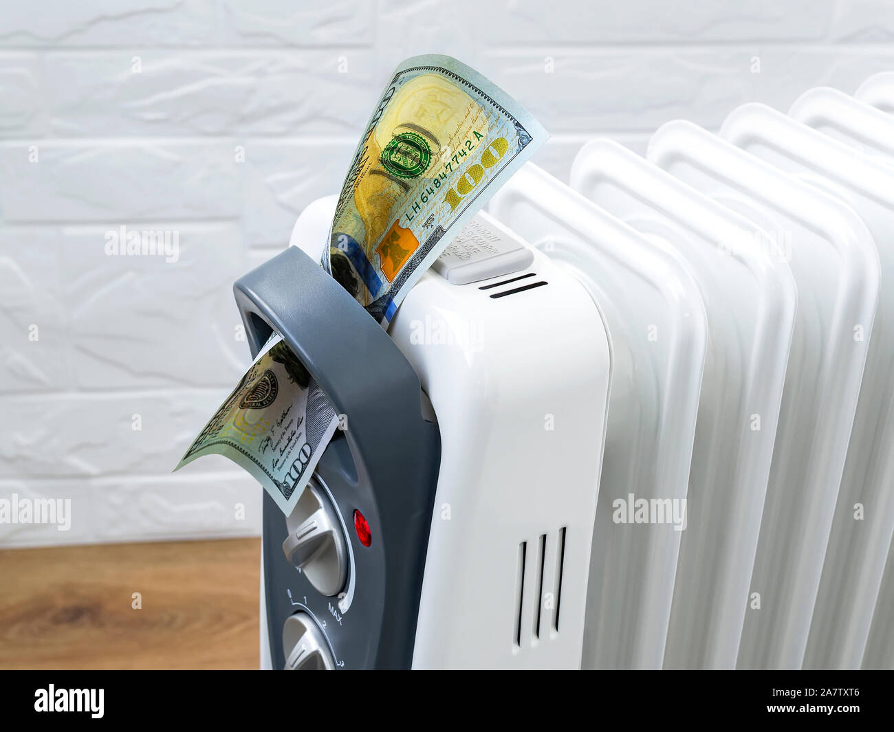 One hundred dollar bill into home electric oil heater. The concept of higher electricity costs