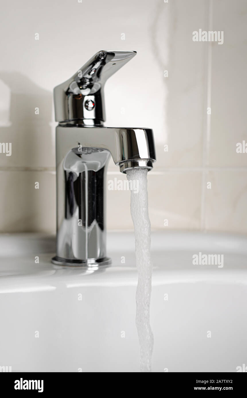Water flows from the tap or faucet in bathroom on white background