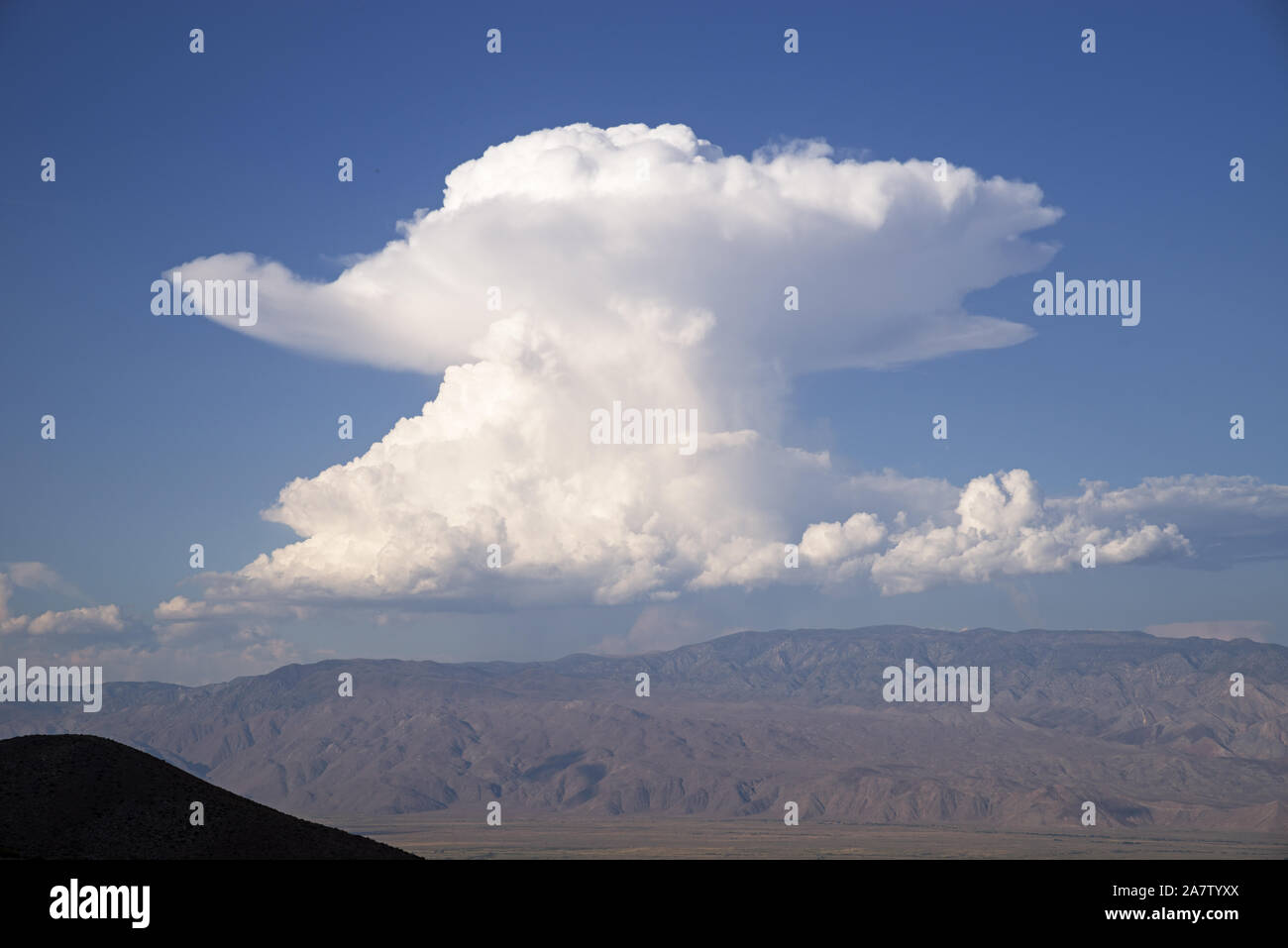 cumulonimbus cloud towers over the Inyo Mountains in a mushroom shape Stock Photo