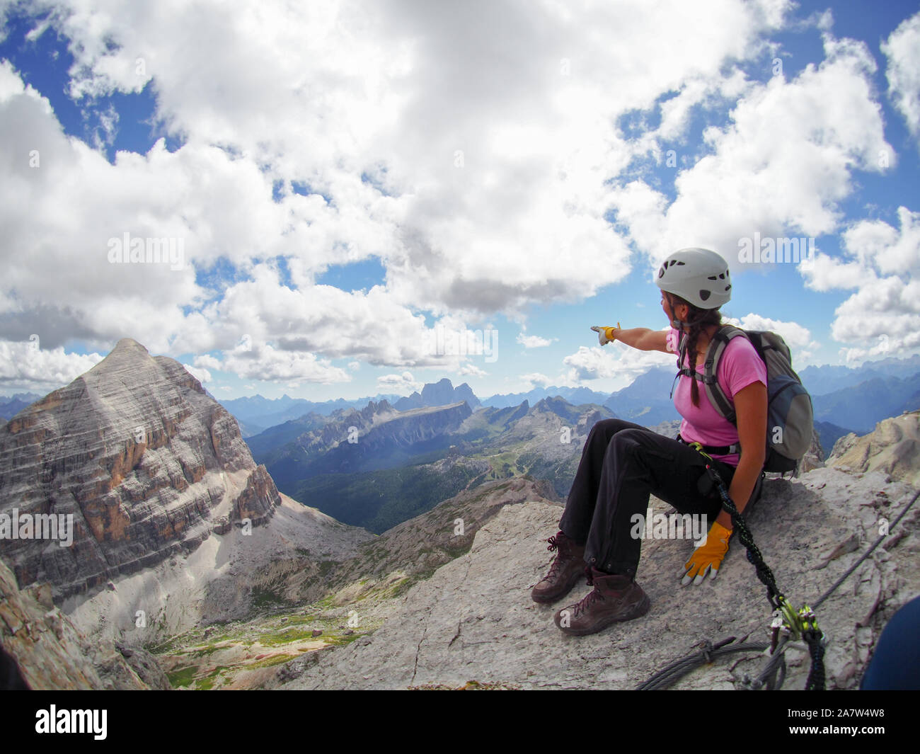 Young attractive female climber on a mountain peak in the